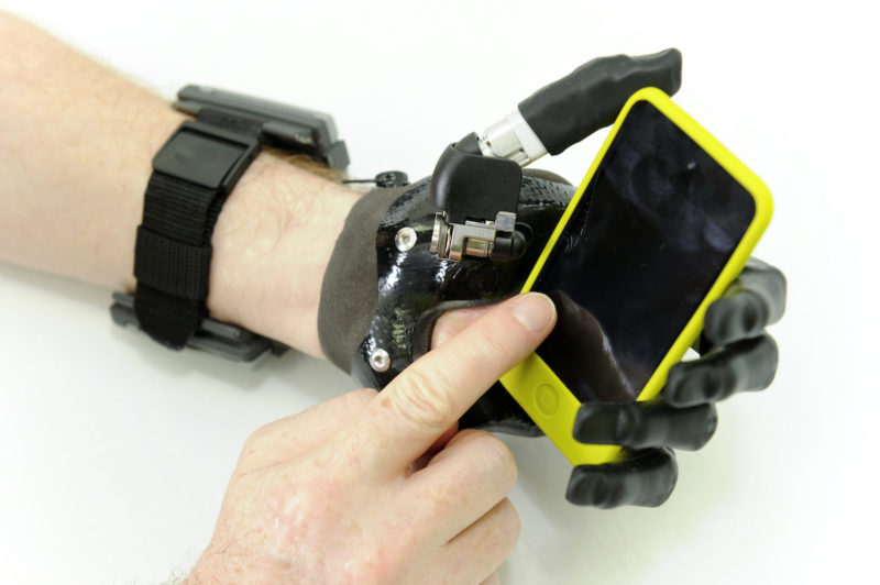 Assistive hand holding a mobile phone