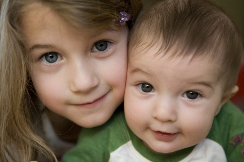 Smiling child holding a baby