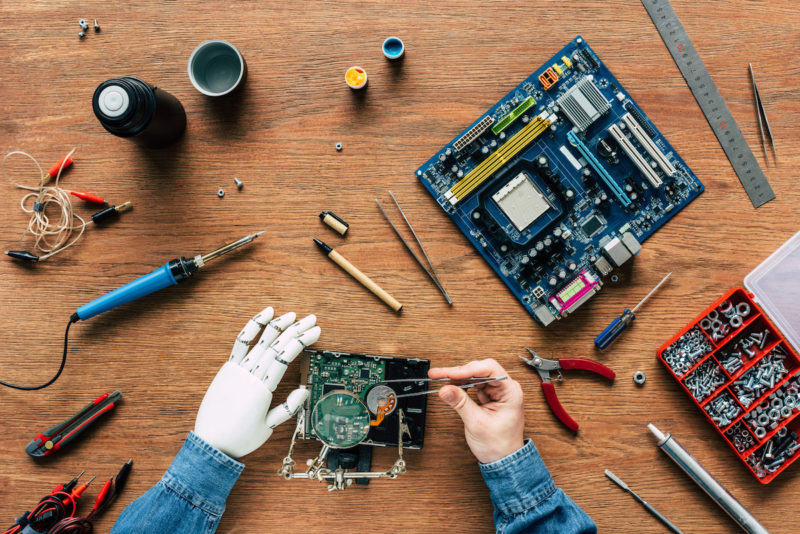 Hands holding tools working on electronic components