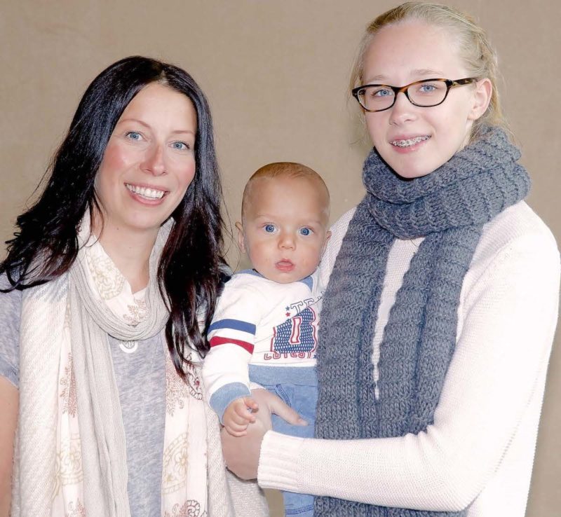 2 women smiling and holding a baby