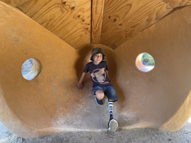 Seb playing on a fort in a children's playground